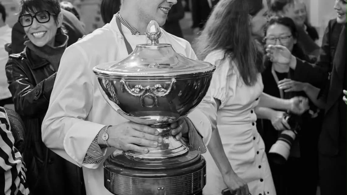 Een chef met de trofee van de Prix ArsNova de Cuisine d’Auteur